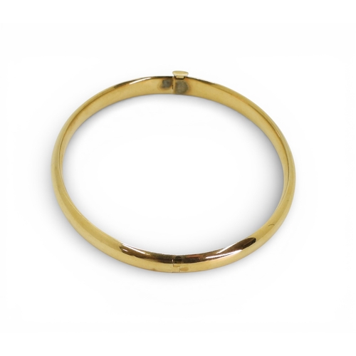 2751 - A CLASSIC PLAIN GOLD BANGLEmade in 14k gold, with gentle domed interior and exterior, the tongue of ... 
