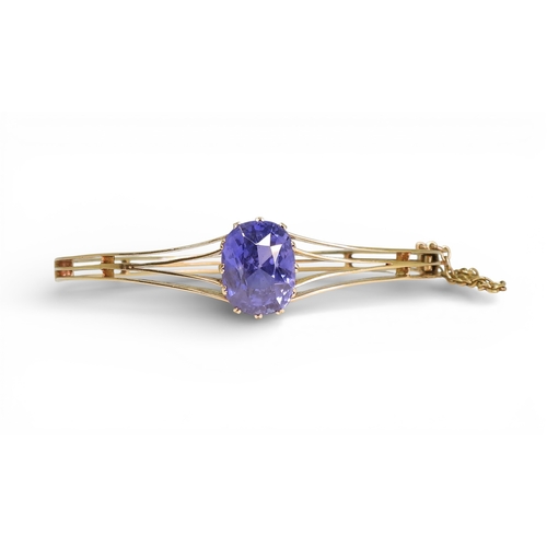 2755 - A SAPPHIRE BANGLEmade in bright yellow metal, and set with a cushion cut natural sapphire of approx ... 