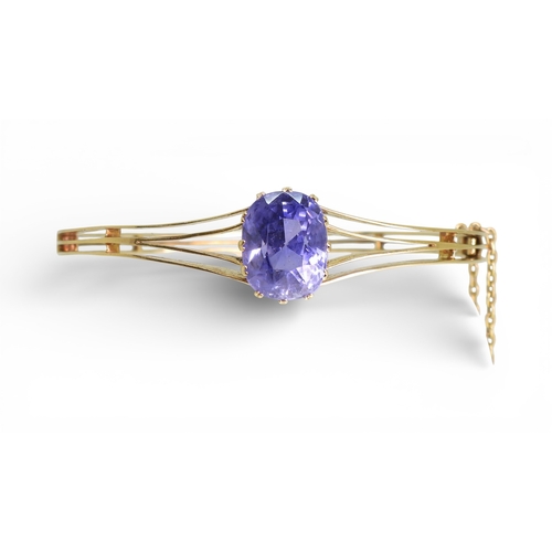2755 - A SAPPHIRE BANGLEmade in bright yellow metal, and set with a cushion cut natural sapphire of approx ... 