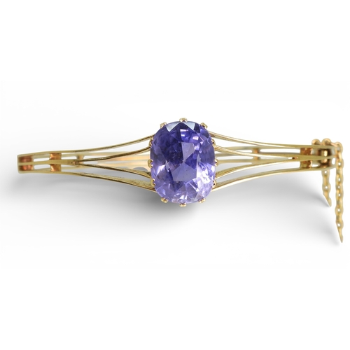 2755 - A SAPPHIRE BANGLEmade in bright yellow metal, and set with a cushion cut natural sapphire of approx ... 