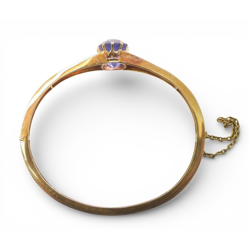 2755 - A SAPPHIRE BANGLEmade in bright yellow metal, and set with a cushion cut natural sapphire of approx ... 