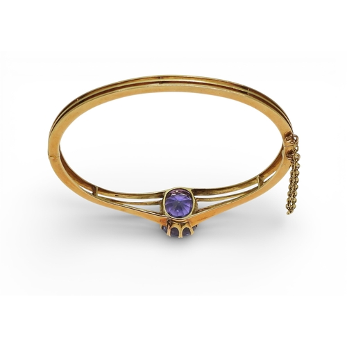 2755 - A SAPPHIRE BANGLEmade in bright yellow metal, and set with a cushion cut natural sapphire of approx ... 