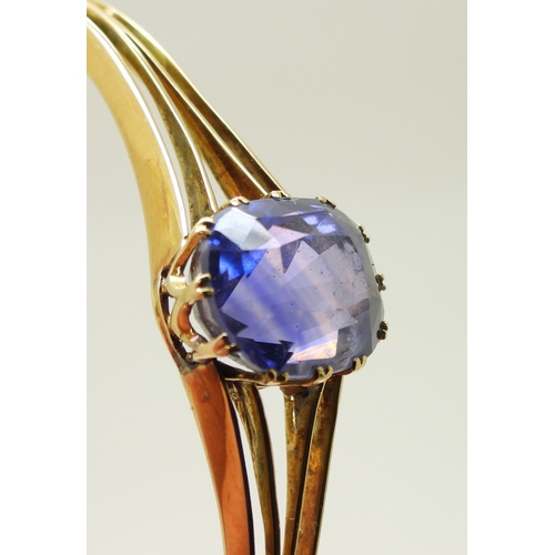 2755 - A SAPPHIRE BANGLEmade in bright yellow metal, and set with a cushion cut natural sapphire of approx ... 