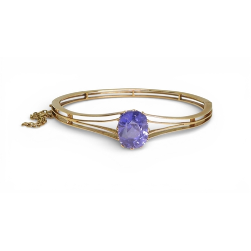 2755 - A SAPPHIRE BANGLEmade in bright yellow metal, and set with a cushion cut natural sapphire of approx ... 