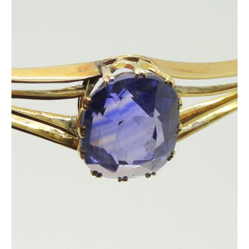 2755 - A SAPPHIRE BANGLEmade in bright yellow metal, and set with a cushion cut natural sapphire of approx ... 