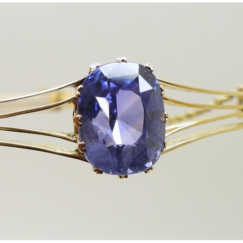 2755 - A SAPPHIRE BANGLEmade in bright yellow metal, and set with a cushion cut natural sapphire of approx ... 