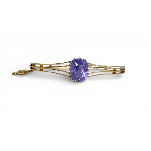 2755 - A SAPPHIRE BANGLEmade in bright yellow metal, and set with a cushion cut natural sapphire of approx ... 