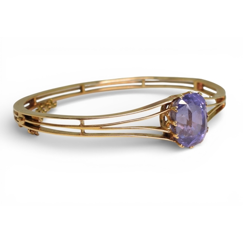 2755 - A SAPPHIRE BANGLEmade in bright yellow metal, and set with a cushion cut natural sapphire of approx ... 