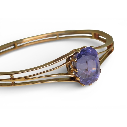 2755 - A SAPPHIRE BANGLEmade in bright yellow metal, and set with a cushion cut natural sapphire of approx ... 