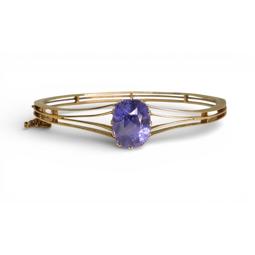 2755 - A SAPPHIRE BANGLEmade in bright yellow metal, and set with a cushion cut natural sapphire of approx ... 