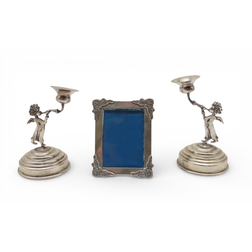 911 - A silver miniature photoframe, 800&nbsp; standard, and two cherub candlesticks, 800 standard, weigha... 