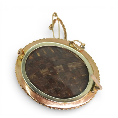 706 - A Victorian yellow metal balloon brooch, with plaited hair under glazed panel, weight 13.6gms