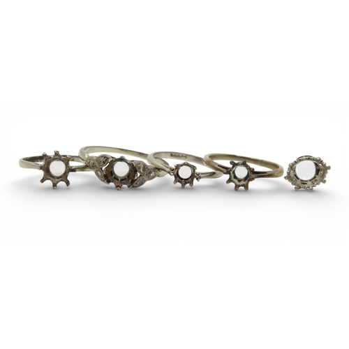 719 - Four bright white metal ring blanks, one stamped PLAT one stamped 18ct and PLAT, and a stone setting... 