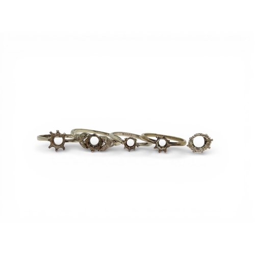 719 - Four bright white metal ring blanks, one stamped PLAT one stamped 18ct and PLAT, and a stone setting... 