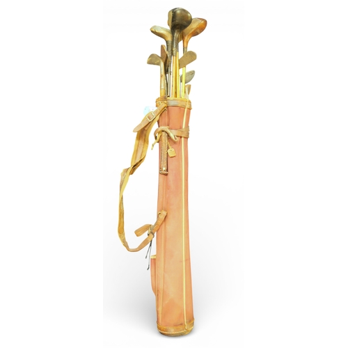 538 - An early-20th century canvas and leather golf bag, containing a selection of hickory shafted clubs, ... 