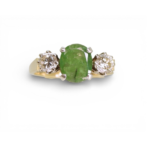 2728 - AN EMERALD & DIAMOND RINGthe 9ct yellow and white gold three stone mount is set with an oval cut... 