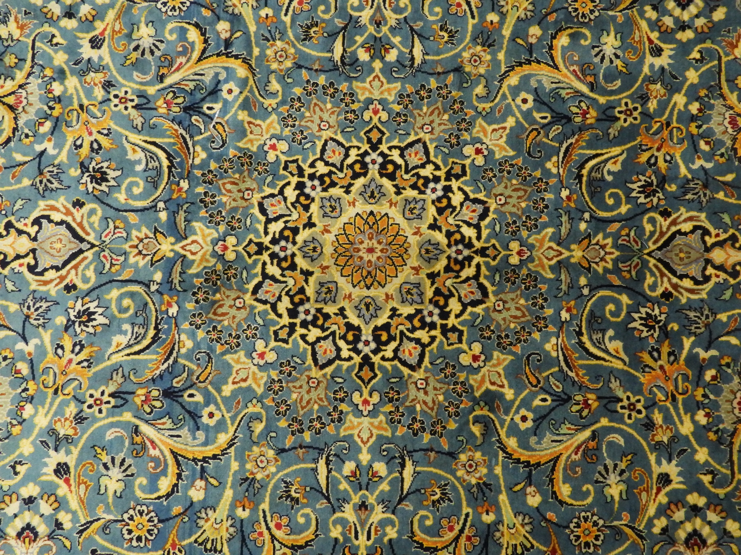 A BLUE GROUND FINE PILE KASHAN RUGwith dark blue sunburst central ...