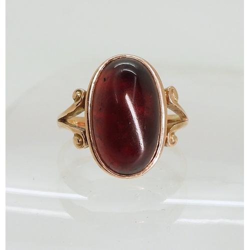 762 - A rose coloured metal ring set with a large garnet of approx 16.5mm x 9.7mm, size M, weight 4.6gms