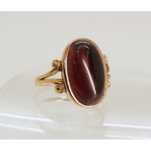 762 - A rose coloured metal ring set with a large garnet of approx 16.5mm x 9.7mm, size M, weight 4.6gms