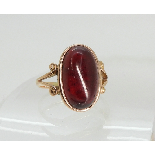 762 - A rose coloured metal ring set with a large garnet of approx 16.5mm x 9.7mm, size M, weight 4.6gms
