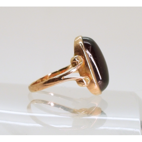 762 - A rose coloured metal ring set with a large garnet of approx 16.5mm x 9.7mm, size M, weight 4.6gms