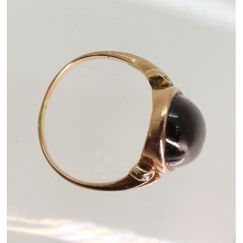 762 - A rose coloured metal ring set with a large garnet of approx 16.5mm x 9.7mm, size M, weight 4.6gms