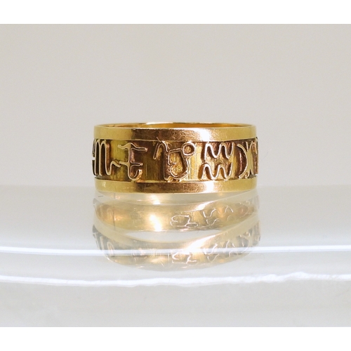 766 - A bright yellow metal Zodiac ring, size k, weight 1.3gms