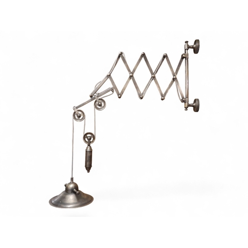 A contemporary industrial style scissor wall mounted light fixture with ...