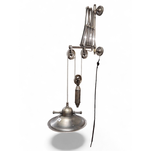 A contemporary industrial style scissor wall mounted light fixture with ...
