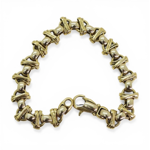2702 - A DECORATIVE BRACELETmade in 18ct yellow and white gold, with cross over design, length 21.5cm, weig... 