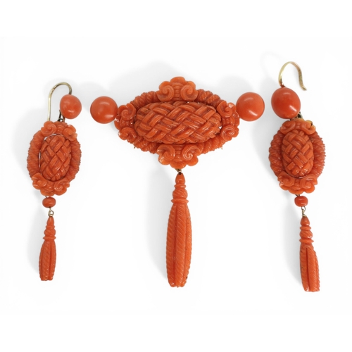2731 - A VICTORIAN CORAL SUITEcomprising of a brooch and earrings, both carved with intricate knotwork, she... 