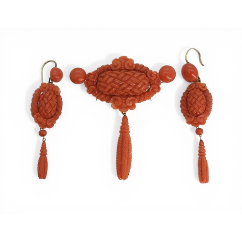 2731 - A VICTORIAN CORAL SUITEcomprising of a brooch and earrings, both carved with intricate knotwork, she... 