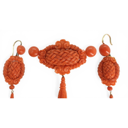 2731 - A VICTORIAN CORAL SUITEcomprising of a brooch and earrings, both carved with intricate knotwork, she... 