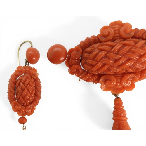 2731 - A VICTORIAN CORAL SUITEcomprising of a brooch and earrings, both carved with intricate knotwork, she... 