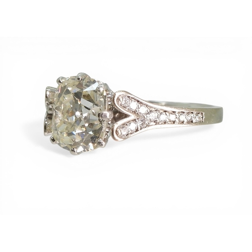 2734 - A SUBSTANTIAL CUSHION CUT DIAMOND RINGre-set in a modern white metal mount, with pave set diamond sh... 