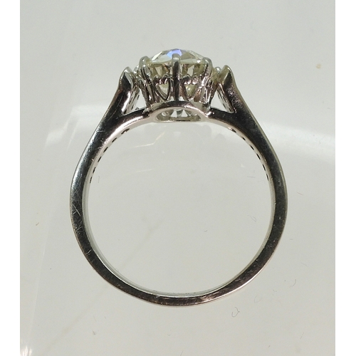 2734 - A SUBSTANTIAL CUSHION CUT DIAMOND RINGre-set in a modern white metal mount, with pave set diamond sh... 