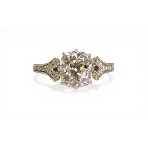 2734 - A SUBSTANTIAL CUSHION CUT DIAMOND RINGre-set in a modern white metal mount, with pave set diamond sh... 