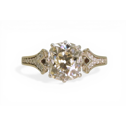 2734 - A SUBSTANTIAL CUSHION CUT DIAMOND RINGre-set in a modern white metal mount, with pave set diamond sh... 