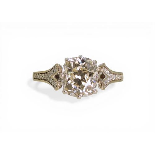 2734 - A SUBSTANTIAL CUSHION CUT DIAMOND RINGre-set in a modern white metal mount, with pave set diamond sh... 