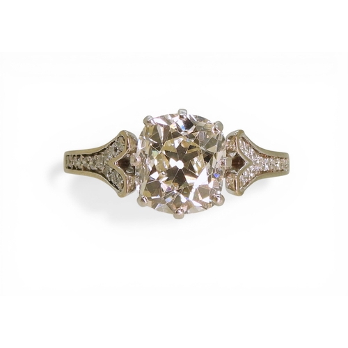2734 - A SUBSTANTIAL CUSHION CUT DIAMOND RINGre-set in a modern white metal mount, with pave set diamond sh... 