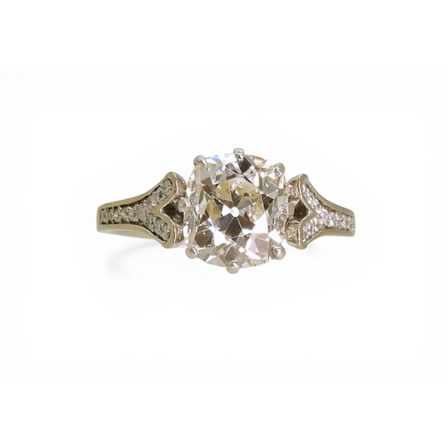 2734 - A SUBSTANTIAL CUSHION CUT DIAMOND RINGre-set in a modern white metal mount, with pave set diamond sh... 