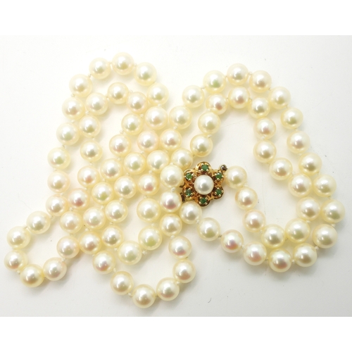 2737 - A MATINEE STRING OF PEARLSthe pearls are cream with a good pink/green lustre, with a 9ct gold, emera... 