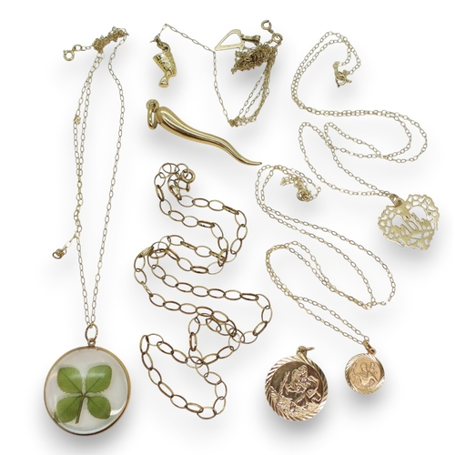 765 - A tangled knot of two chains, both clasps stamped 9k, with 9ct gold Nefertiti and V pendants, furthe... 