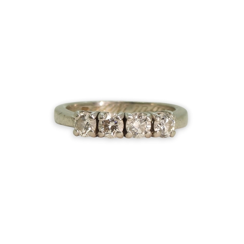 776 - A bright white heavy metal (un-hallmarked platinum) four stone diamond ring, set with estimated appr... 