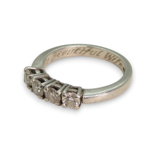 776 - A bright white heavy metal (un-hallmarked platinum) four stone diamond ring, set with estimated appr... 