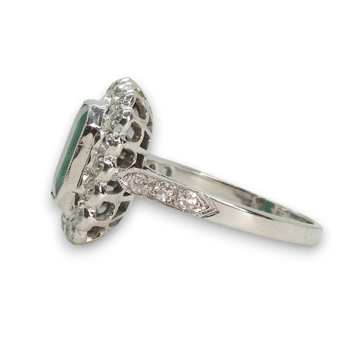 794 - An 18ct white gold emerald and diamond cluster ring, set with a step cut emerald of approx 9mm x 7mm... 
