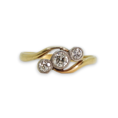 805 - An 18ct gold three stone diamond ring on a twist, set with three old cut diamonds with an estimated ... 