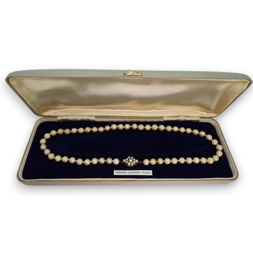808 - A string of cultured pearls with a 9ct gold pearl flower clasp, length 44.5cm