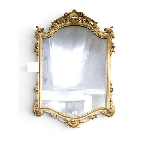 10 - A late 19th century gilt framed wall mirror with scrolled floral/foliate frame, 102cm high x 69cm wi... 