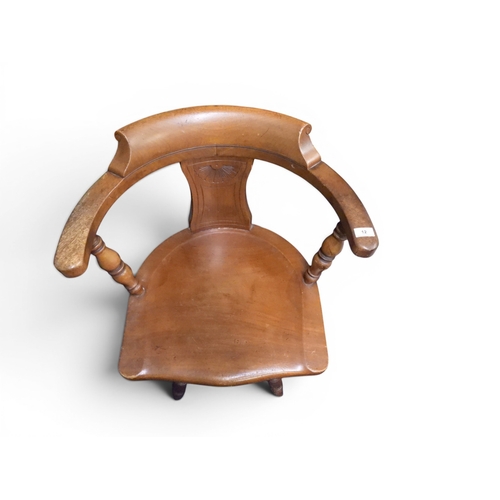 12 - An early 20th century stained beech horseshoe back desk chair with shaped back with turned uprights ... 